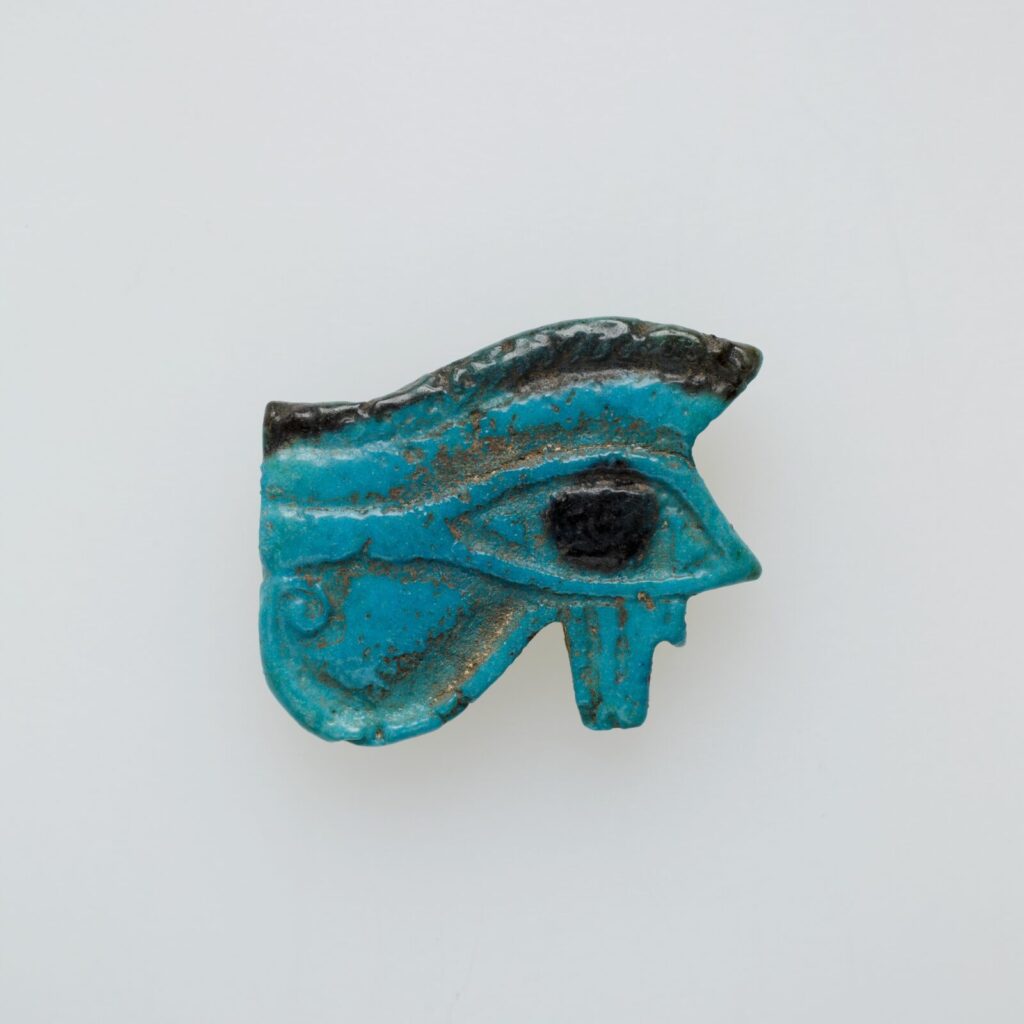 Egipski amulet oka wedżat z turkusowego fajansu, z czarną źrenicą, brwią, kreską pod okiem i spiralną wolutą