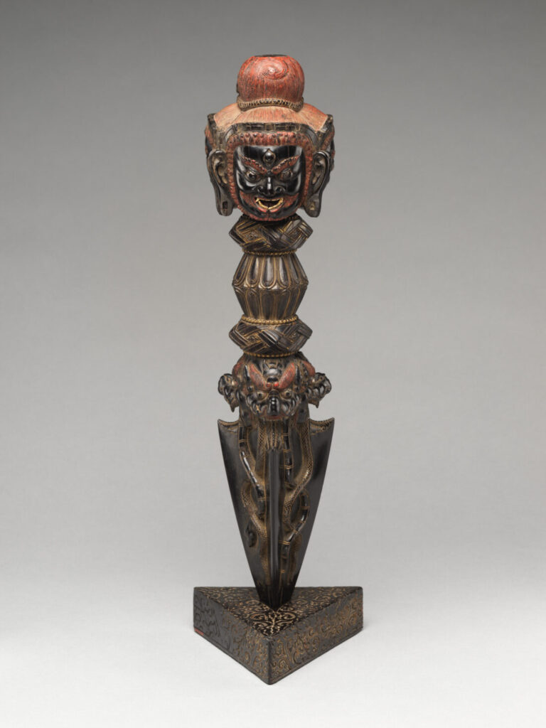 Phurba z podstawką, Metropolitan Museum of Art Ciemny sztylet rytualny z rzeźbioną głową u góry, osadzony w stojaku