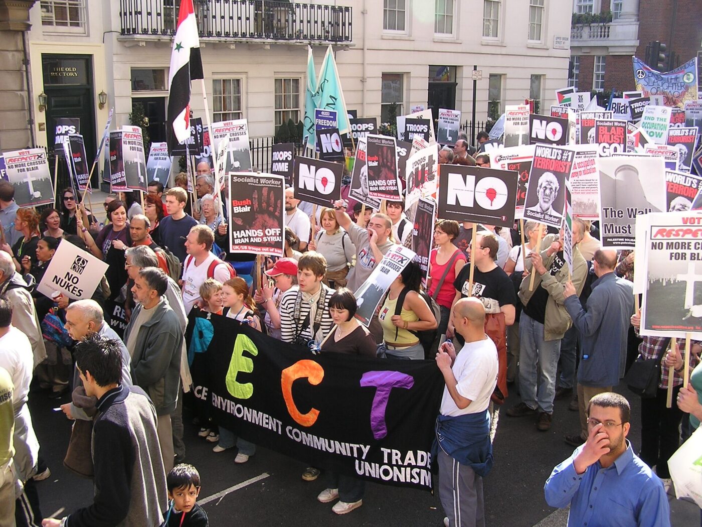 Tłum demonstrantów z transparentami i znakami pacyfki podczas marszu antywojennego w Londynie w 2005 roku