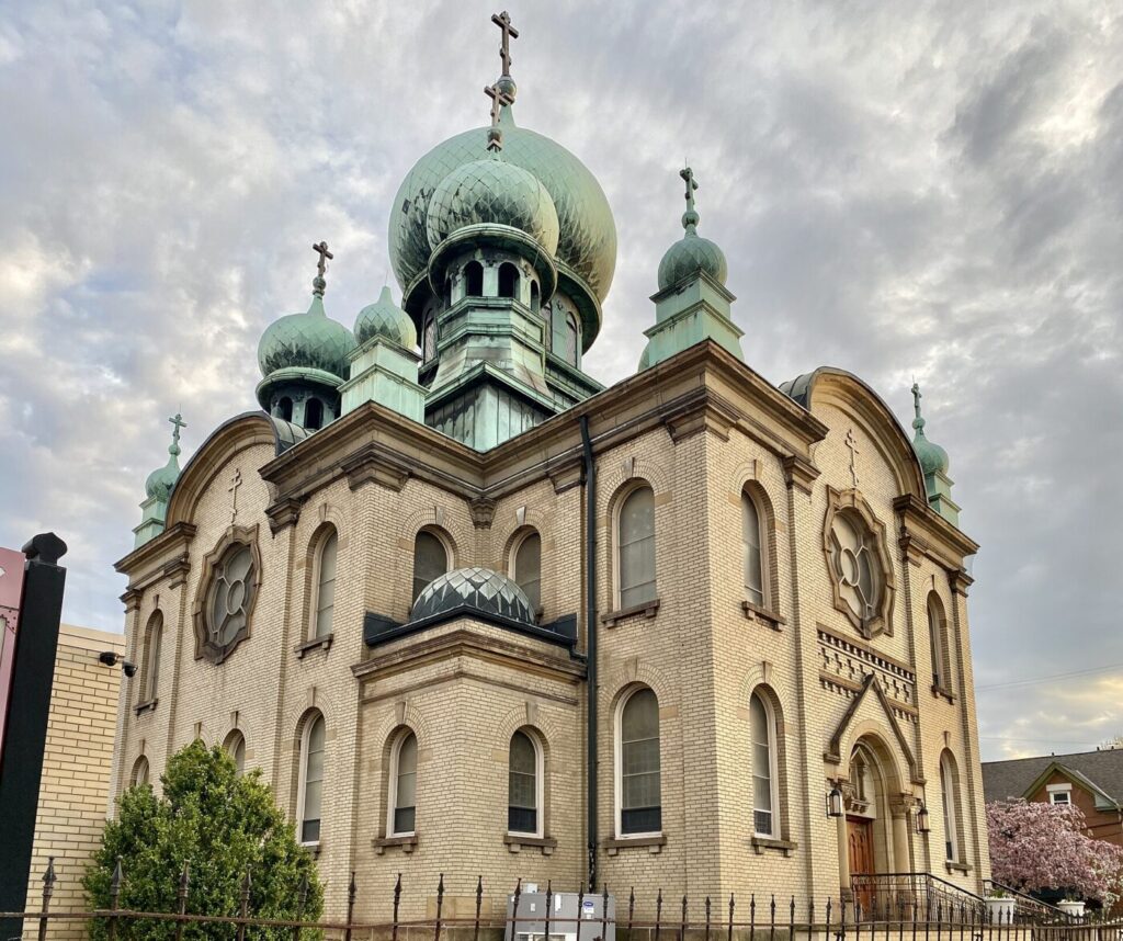 Zielone cebulaste kopuły cerkwi zwieńczone ośmiokończastymi krzyżami prawosławnymi